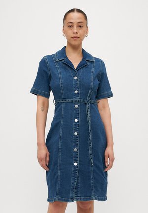 Denimkjole med korte ermer, krage, frontlukking med knapper og belte i midjen. Har en blå vask og kontrasterende sømdetaljer.