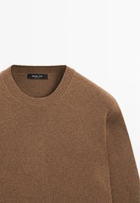 Hnědý pletený svetr s kulatým výstřihem, který má jemnou texturu. Nálepka uvádí "Massimo Dutti", což označuje značku.