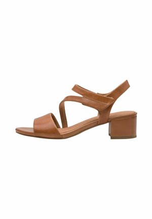 Tanfarvet lædersandal med blokkæk, der har krydsede remme og et åbent tådesign. Glat tekstur og minimalistiske designdetaljer.