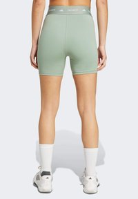 Mint green athletic shorts with an elastic waistband featuring the "TECHFIT" logo. Smooth texture with fitted design, perfect for workouts.