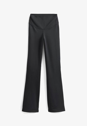 Zwarte yogabroek gemaakt van rekbaar materiaal, met een brede tailleband, flared benen en een gladde textuur met minimale stikdetails.