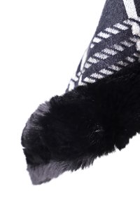 Finitura in pelliccia sintetica nera con un tessuto di lana testurizzato caratterizzato da un motivo geometrico in grigio e bianco. Il design mette in risalto il calore e la morbidezza.