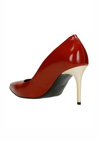 Czerwony szpilka z błyszczącym wykończeniem, szpiczastym czubkiem, ażurowym wzorem i zwężającym się złotym obcasem. Czarna podeszwa z detalem marki.