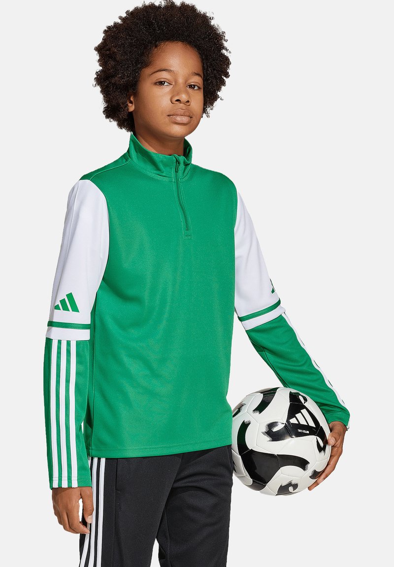 Groene sweatshirt met witte mouwen en drie-strepenaccenten; gladde textuur; staat met een voetbal in de hand.