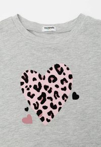Graues Baumwoll-T-Shirt mit einem großen Herzdesign aus pinkem Leopardenmuster sowie zusätzlichen kleineren Akzenten in schwarz und pink.