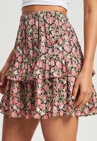 Mini sukně s květinovým potiskem v černé barvě, která má růžové a zelené květiny, volánkové vrstvy a elastický pas pro pohodlí.