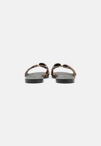 Flat sandals with leopard-print straps, smooth black soles, and an open-toe design. The straps feature a unique crossed pattern.