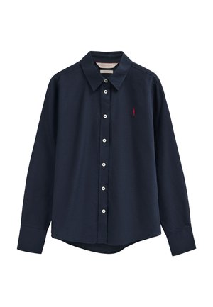 Marineblaue langärmelige Hemdbluse mit Kragen, weißen Knöpfen entlang der Vorderseite und kleinem roten, gesticktem Logo auf der linken Brust.