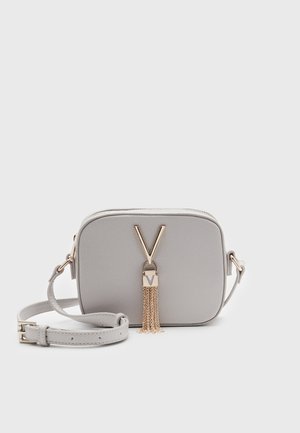 Borsa a tracolla grigio chiaro in materiale testurizzato, con un accento oro a forma di V e un dettaglio a nappa. Include una tracolla regolabile.