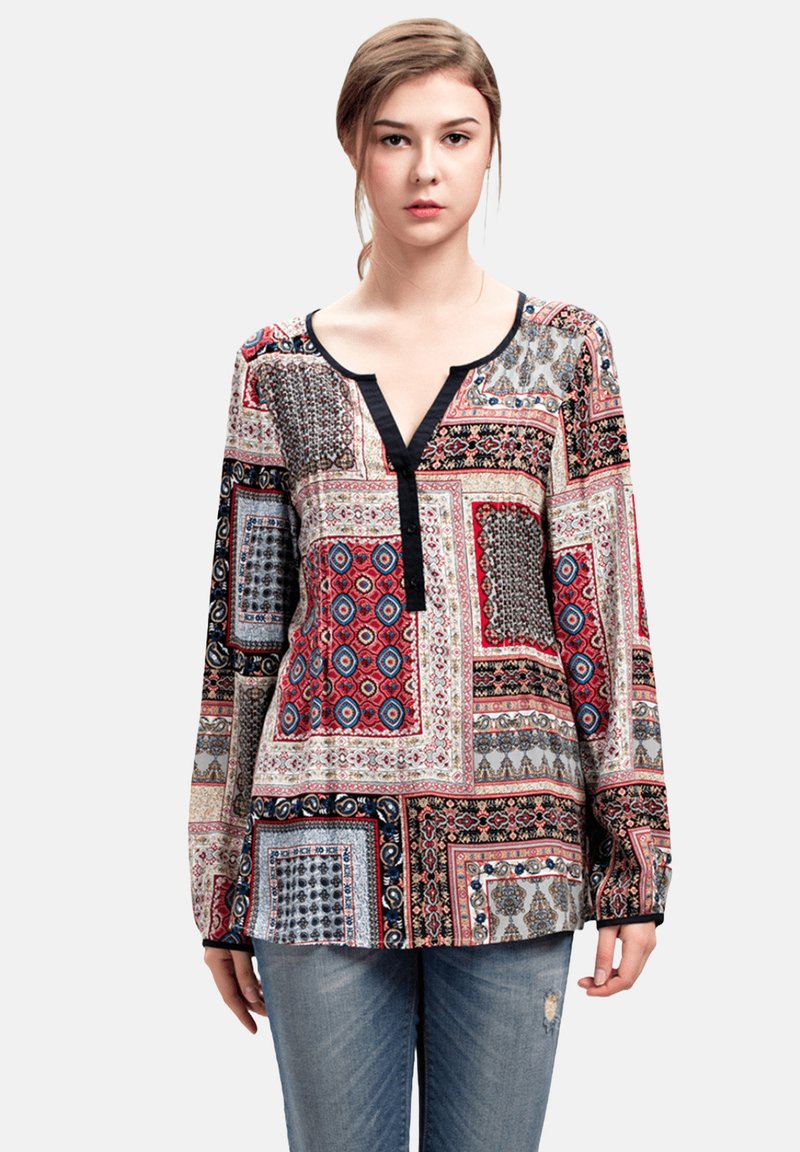 Blusa de manga larga con patrones mezclados en rojo, negro y gris. Presenta un escote en V con una tapeta negra en contraste y un corte relajado.