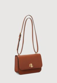 Borsa a spalla in pelle marrone con chiusura a pattina magnetica e accentuazione del logo in tonalità dorata. Presenta una tracolla regolabile bicolore.