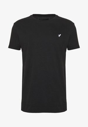 Juodas trumpomis rankovėmis marškinėliai iš medvilnės, su apvalia iškirpte ir mažu baltu paukščio logotipu kairėje krūtinės pusėje.