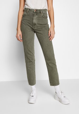 Hoge taille, olijfgroene jeans met een rechte pijpdesign, voorzien van vijf zakken en koperen knoopaccenten, gecombineerd met witte sneakers.