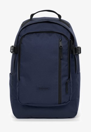 Dunkelblauer Rucksack aus strapazierfähigem Stoff, mit mehreren Reißverschlussfächern und einem oberen Griff zum Tragen. Eastpak-Logo sichtbar.