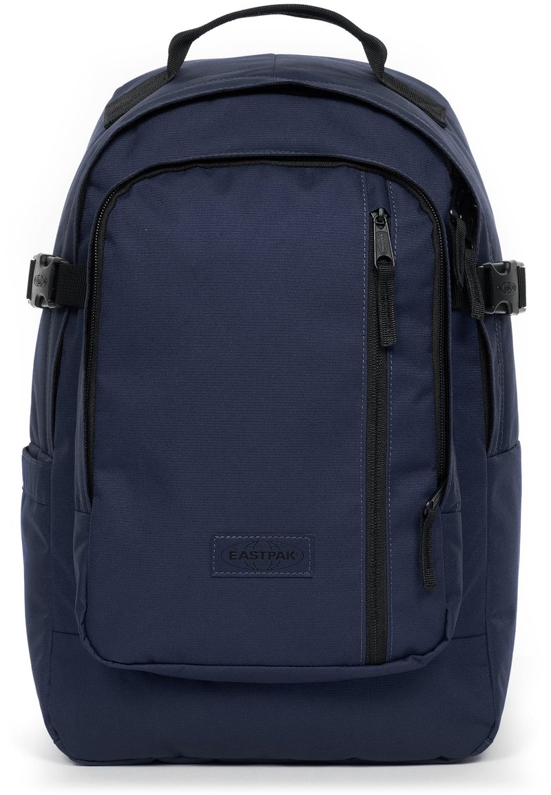 Mochila azul marino hecha de un tejido duradero, con múltiples compartimentos con cremallera y una asa superior para llevarla. Logo de Eastpak visible.