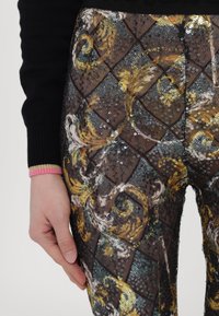 paljetterte leggings med et rutemønster i gull, svart og blå nyanser; har en teksturert finish og høy midje.