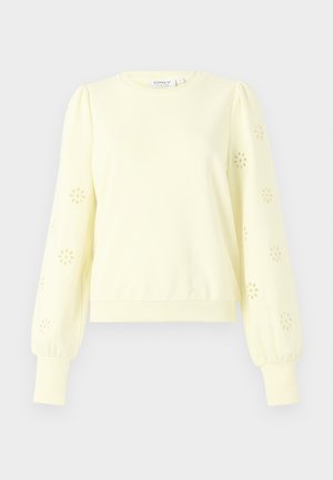 Felpa giallo pallido con scollo rotondo, maniche a sbuffo, intagli floreali a occhiello e polsini e orlo a costine. Tessuto morbido.