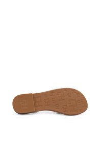 Suola in gomma abbronzata con un motivo testurizzato che presenta forme geometriche e accenti lineari. Finitura liscia, punta arrotondata.