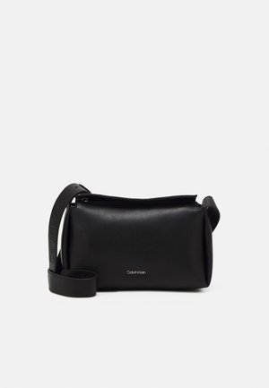 Schwarze Leder-Umhängetasche mit einem Reißverschluss, ausgestattet mit einem strukturierten Tragegurt, der mit dem Markennamen geprägt ist, und einem minimalistischen Design.