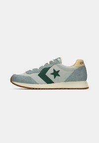 Retro sneakers featuring a light blue upper with suede accents, dark green star and arrow design, beige heel, and rubber sole.