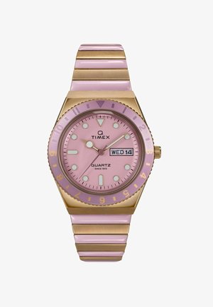 Timex Quarz-Uhr mit pinkem Ziffernblatt, goldenen Akzenten, einer drehbaren Lünette und einem pinken Metallband mit flachen Gliedern sowie einem Wochendatumsdisplay.