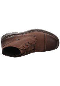 Botín de cuero marrón hasta el tobillo con punta redonda, superficie texturada, acentos cosidos y cordones con patrón; suela de goma para tracción y durabilidad.