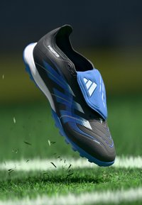 Crne i plave nogometne kopačke s aerodinamičnim dizajnom, sintetičkom gornjom površinom, teksturiranom površinom i plavom navlakom za vezice s logotipom.