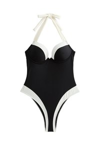 Bañador negro de una pieza con acentos blancos. Presenta copas con relleno y tirantes atados al cuello. Diseño de corte alto, tela suave y estilo minimalista.