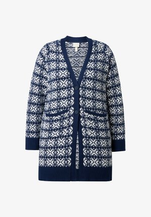 Námorně modrý svetr s bílými geometrickými vzory, výstřihem do V, dvěma předními kapsami a žebrovanými manžetami a lemem. Vyroben z texturovaného pleteného materiálu.