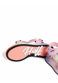 Sandalias rosas y moradas con una suela texturizada, que cuentan con correas de velcro y un logo blanco "Hoff" en la suela exterior.