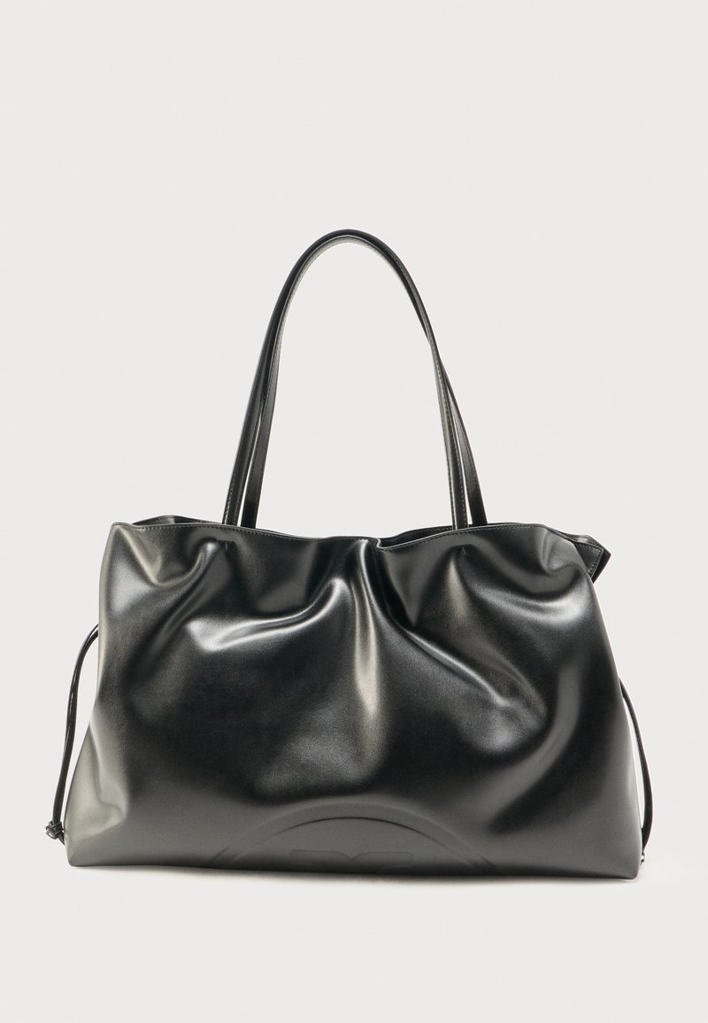 Sac fourre-tout en cuir noir brillant avec deux bretelles d'épaule et une texture légèrement froissée, présenté sur un fond clair uni.