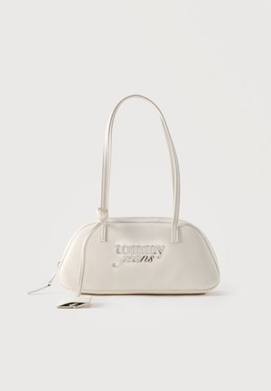 Kermanvärinen suorakaiteen muotoinen olkalaukku, jossa pitkät hihnat, "tommy jeans" -logo hopeanvärisenä etuosassa ja vetoketjuun kiinnitetty roikkuva nimilappu.