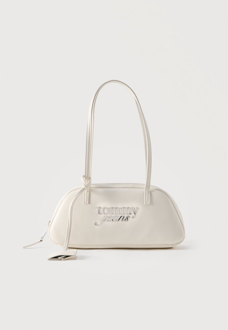 Κρεμ ορθογώνια τσάντα ώμου με μακριά λουριά, λογότυπο "tommy jeans" σε ασημί στο εμπρός μέρος και αναρτημένη ετικέτα προσαρτημένη στο φερμουάρ.