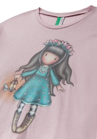 Camiseta de color rosa claro con una chica de dibujos animados que lleva un vestido verde azulado con patrones de corazones, cabello oscuro y sosteniendo una linterna. Tejido suave con un corte relajado.