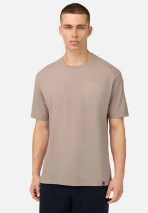 Beige T-Shirt mit kurzen Ärmeln aus weichem Stoff, ausgestattet mit einer Brusttasche und einem lässigen Schnitt. Texturiertes Material mit glatter Optik.