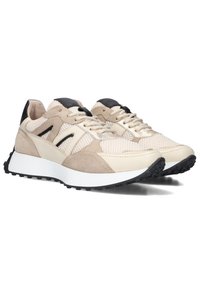 Beige and cream athletic sneakers with suede and mesh panels, black accents, and textured rubber soles. Laced design with a cushioned collar.