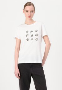 T-shirt bianca in cotone con icone stampate nere, tra cui sole, stella marina, conchiglia, alga e motivi ondosi. Design a maniche corte e colletto rotondo.