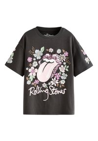 Svart bomullst-shirt med ett blomsterdesign som inkluderar en rosa tunga och glittrande detaljer, märkt med "Rolling Stones" i vit stiliserad text.