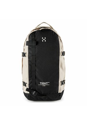 Großer zweifarbiger Rucksack in Schwarz und Beige mit vorderen Gurten, seitlichen Schnallen, einem oberen Tragegriff und der Aufschrift "TIGHT" auf der Fronttasche.