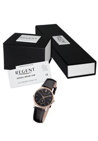 Montre à bracelet en cuir noir avec un cadran noir rond, accents en or rose, chiffres romains et un affichage de date. Comprend des boîtes noires et une carte de garantie.
