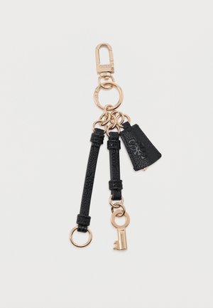 Nøglering i guldfarvet tone med sorte læderstropper med struktur, en lille nøglevedhæng og en trekantet lædermærkat med præget logo.