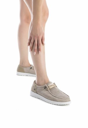 Zapato ligero beige con parte superior de punto, cordones elásticos, suela de goma blanca y diseño minimalista. Adecuado para uso informal.