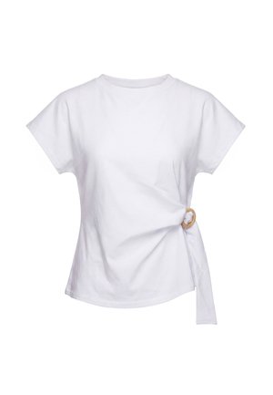 T-shirt bianca a maniche corte con scollo rotondo e dettaglio fiocco annodato sul lato con anello marrone chiaro nella zona destra della vita.