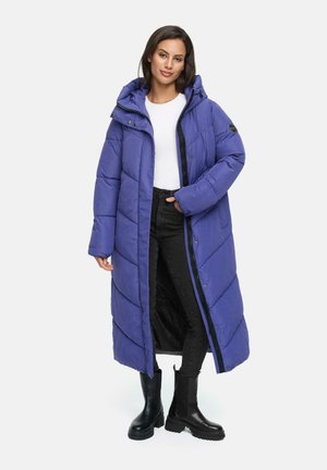 Long padded coat in vibrant purple, featuring a zip front, hood, and rectangular quilted pattern. Paired with black pants and knee-high boots.