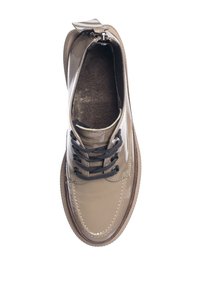 Chaussure à lacets en cuir verni beige unique avec lacets noirs et semelle marron vue de dessus sur fond blanc.