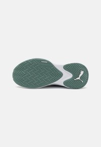 Semelle de chaussure en caoutchouc vert avec un motif en chevrons, semelle intermédiaire blanche et logo Puma sur le bord extérieur. Conçu pour l'adhérence et le soutien.