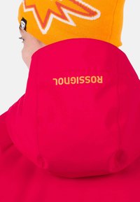 Heller pinker Kapuzenpullover mit einer gelben Mütze im Muster, auf der Rückseite der Kapuze befindet sich der Markenname "Rossi gnu t" in fettem orangefarbenen Text.