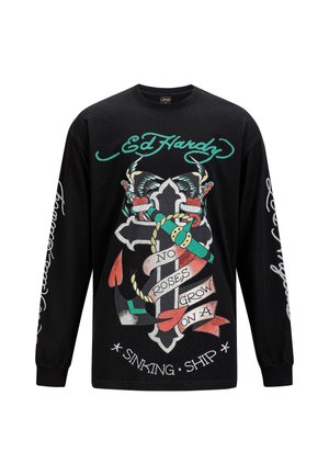 Black long-sleeve shirt featuring bold graphics of a cross, butterflies, and ribbons with text. Printed accents in red, green, and white.