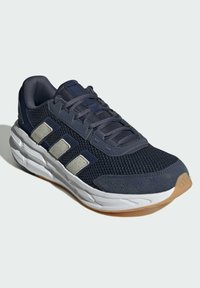 Ciemnoniebieskie buty sportowe z siateczkową cholewką, szarymi tonalnymi akcentami i miękką białą podeszwą pośrednią. Posiada płaskie sznurowadła i teksturowaną gumową podeszwę.