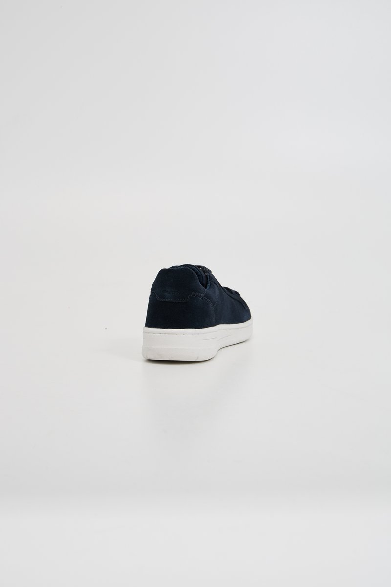 Sneaker in camoscio blu navy con profilo basso, suola in gomma bianca, punta rotonda e dettagli di cucitura discreti sul tallone posteriore.